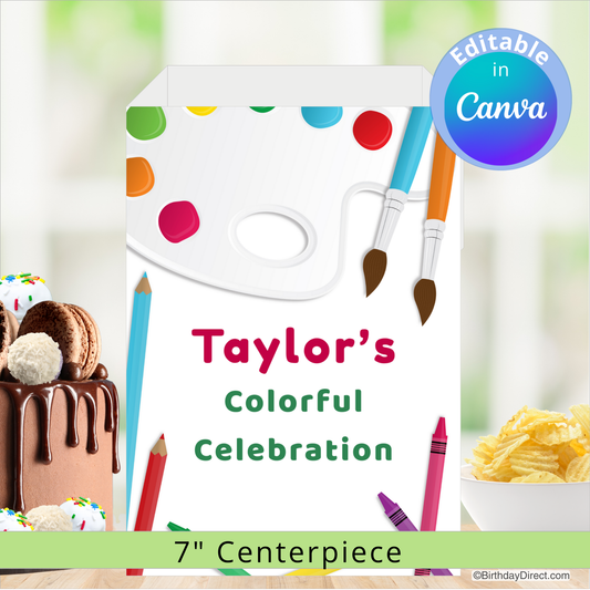 Birthday centerpiece decoration with paint palette, cake, and crayons on a blurred background.