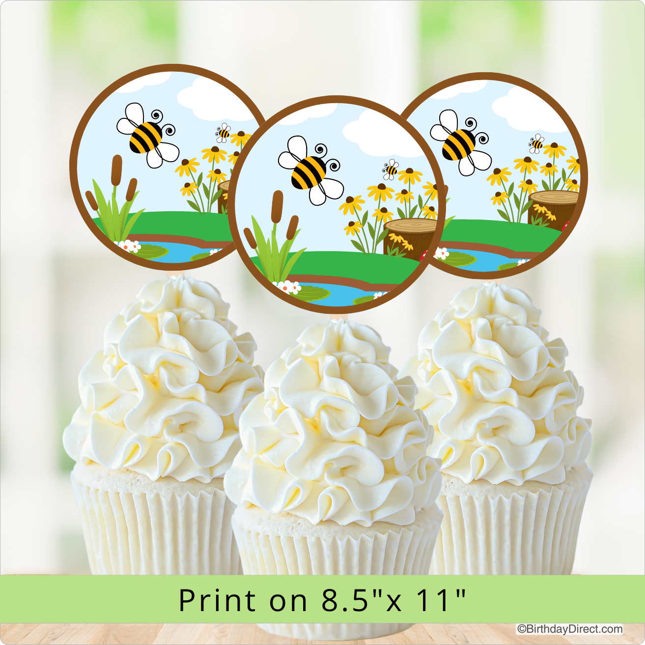 Cupcakes with white frosting and bee-themed toppers on a light green background.