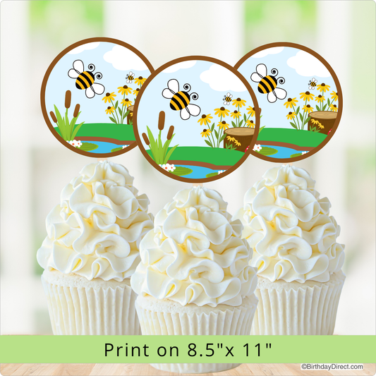 Cupcakes with white frosting and bee-themed toppers on a light green background.