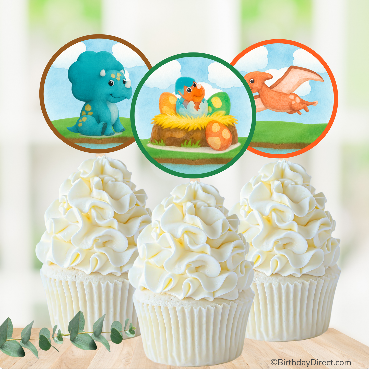 Cupcakes with dinosaur-themed toppers on a blurred natural background