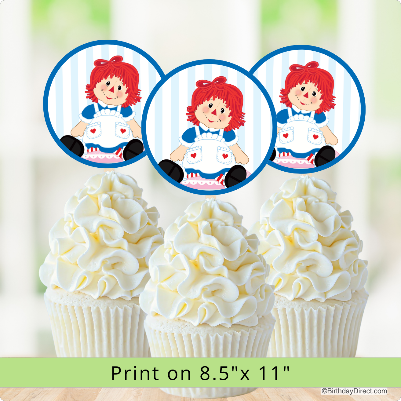 Cupcakes with white frosting and a Raggedy Ann Doll on top, with a print size note.